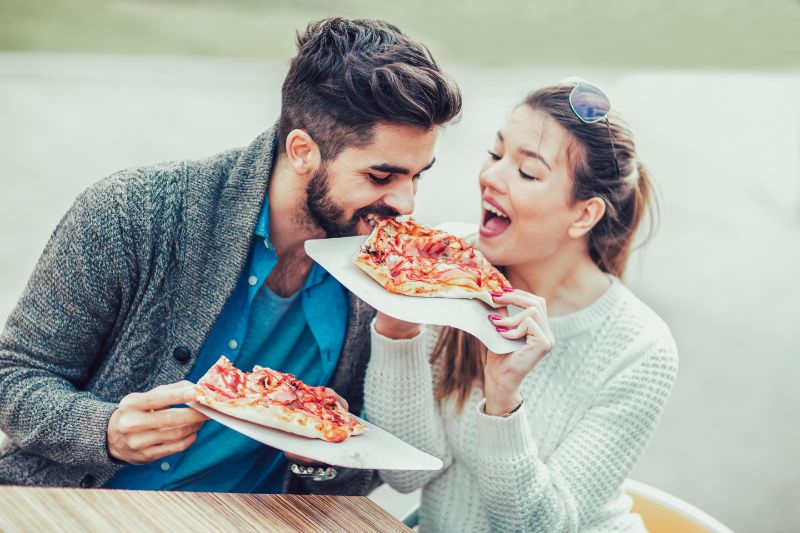 Paar-essen-Pizza-Snack-im-Freien-und-haben-Spas