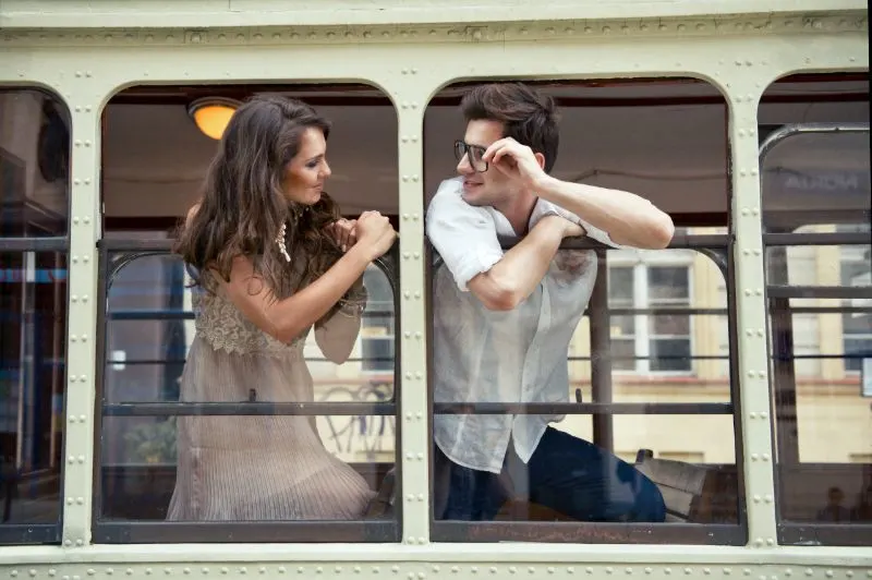 Paar mit Köpfen aus dem Straßenbahnfenster. Liebe