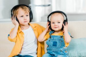 Entzückende Brüder, die zu Hause Musik in Kopfhörern hören