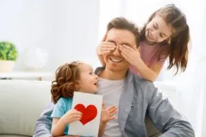 Glückliche Kinder mit Vatertagsgeschenken, die Spaß mit Vater halten Grußkarte mit ich liebe dich Papa Inschrift und Herz Symbol