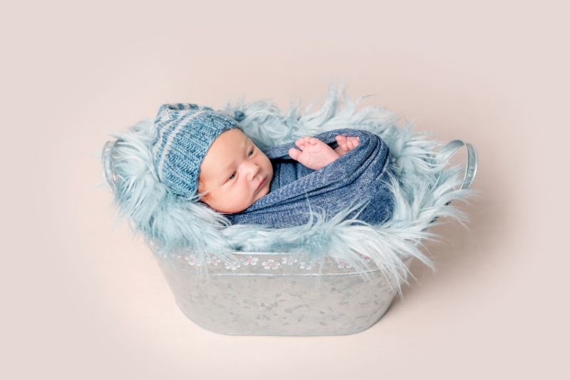 Neugeborenes-Baby-das-im-Trog-mit-einer-blauen-Decke-liegt-1