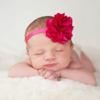 Neugeborenes-Baby-mit-heisem-rosa-Blumenstirnband