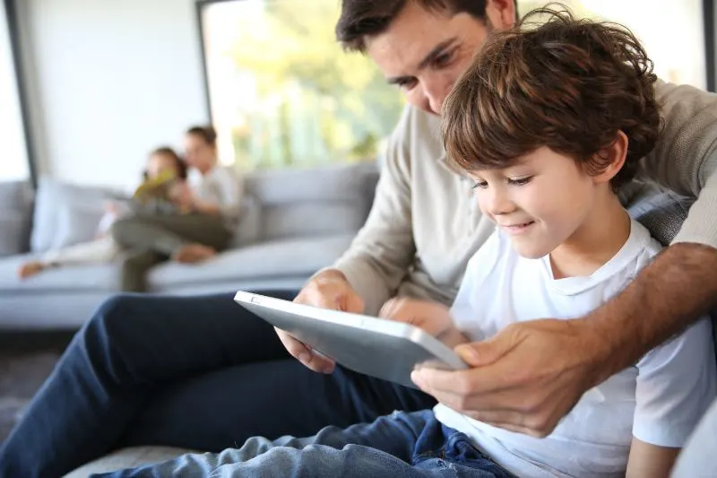 Vater-und-Sohn-spielen-mit-digitalem-Tablet
