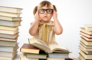 Kleines Mädchen mit Büchern, die Brille tragen