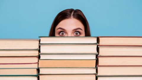 Nahaufnahmeporträt eines Mädchens in Brillen, die Bücher halten