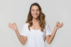 Ruhige ruhige Frau, die Yogaübungen auf weißem leerem Hintergrund tut