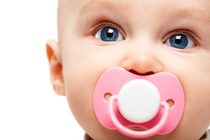 suses-Kind-mit-blauen-schonen-Augen-und-einem-Babyschnuller