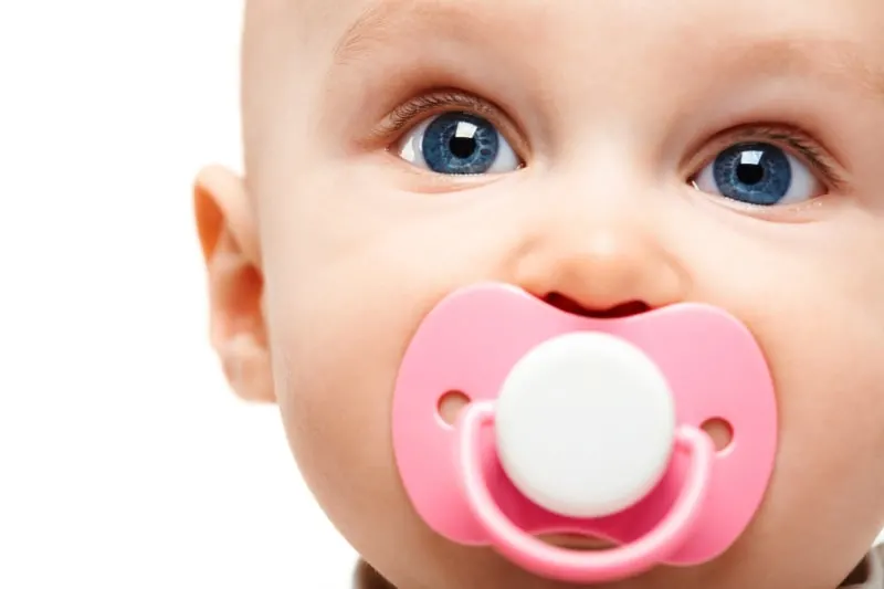 suses-Kind-mit-blauen-schonen-Augen-und-einem-Babyschnuller