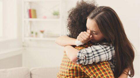 Frau umarmt ihren depressiven Freund zu Hause