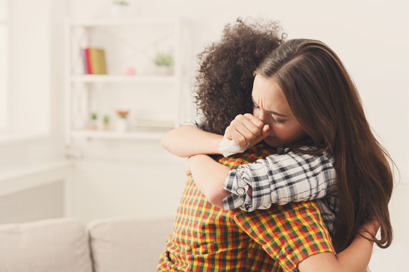 Frau umarmt ihren depressiven Freund zu Hause