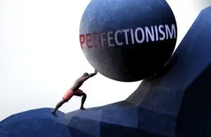 Perfektionismus als Problem, symbolisiert durch eine Person, die mit dem Wort Perfektionismus Gewicht drückt, um zu zeigen, dass Perfektionismus eine schwer zu tragende Last sein kann