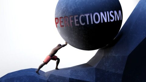 Perfektionismus als Problem, symbolisiert durch eine Person, die mit dem Wort Perfektionismus Gewicht drückt, um zu zeigen, dass Perfektionismus eine schwer zu tragende Last sein kann