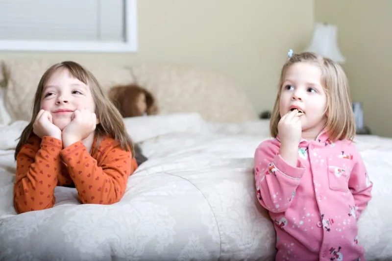 Zwei-suse-Schwestern-schauen-im-Schlafzimmer-ihrer-Eltern-fern