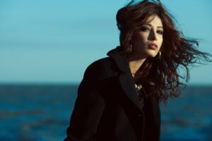 Emotionales Porträt einer schönen Brünette mit langen Locken