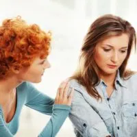 Gestörtes Mädchen, das von ihrer Freundin getröstet wird