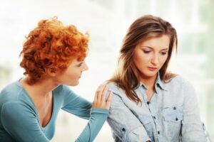 Gestörtes Mädchen, das von ihrer Freundin getröstet wird