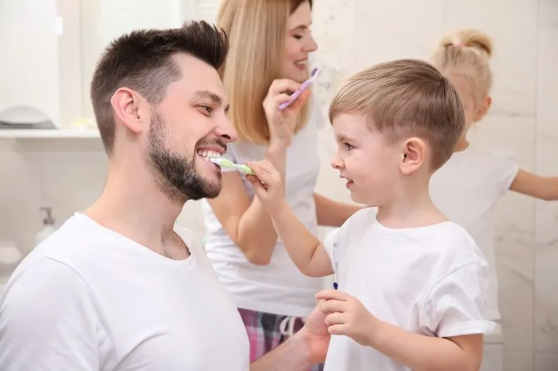 Junge-hilft-Vater-beim-Zahneputzen