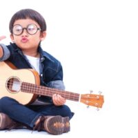 Netter Junge, der die Ukulele spielt