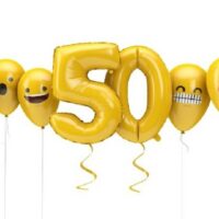 Nummer 50 gelbes Geburtstags-Emoji steht vor Ballons.