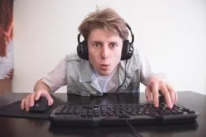 Porträt eines lustigen Spielers mit erstauntem Gesicht beim Spielen auf einem Computer.