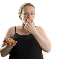 Schwangere Frau isst Fast Food, Croissant, zu viel