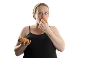 Schwangere Frau isst Fast Food, Croissant, zu viel