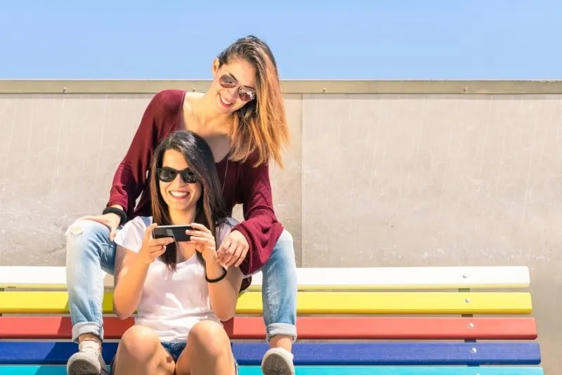 Beste-Freunde-geniesen-die-gemeinsame-Zeit-im-Freien-mit-dem-Smartphone
