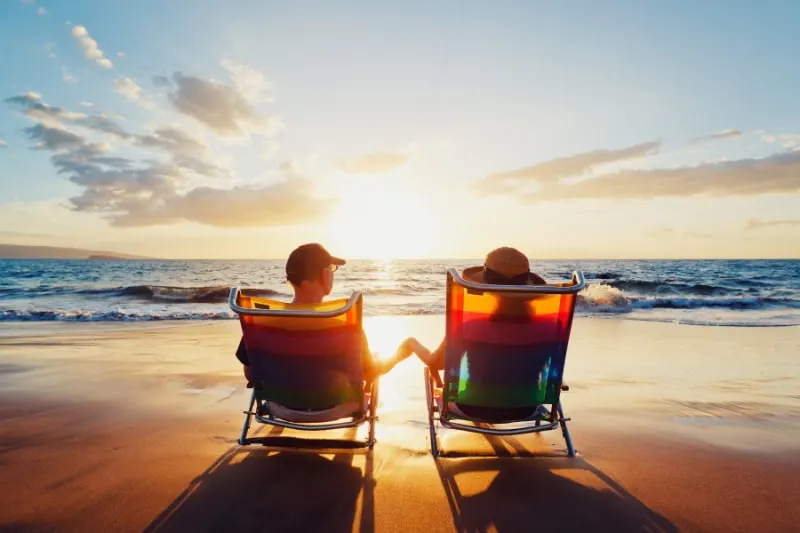 Gluckliches-romantisches-Paar-das-den-schonen-Sonnenuntergang-am-Strand-geniest