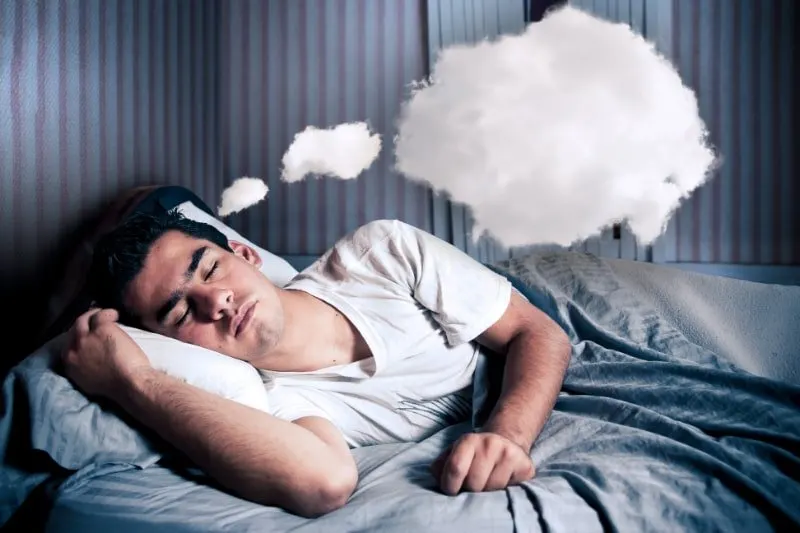 Mann-traumt-bequem-in-seinem-Bett-mit-einer-Wolke