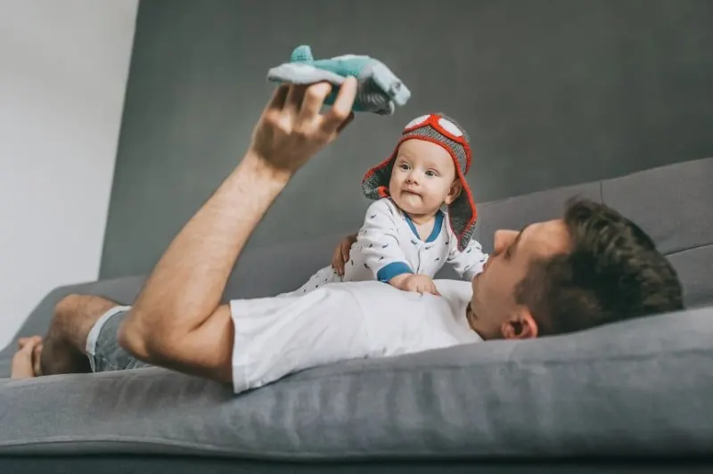 Vater-halt-Spielzeugflugzeug-und-spielt-mit-entzuckendem-Kind