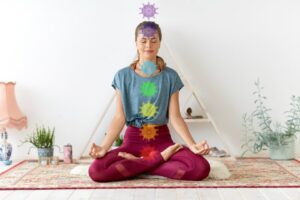 Frau meditiert im Lotussitz im Yogastudio
