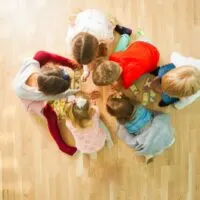 Gruppe von Kindern, die Bildungskarten auf einer Etage spielen. Puzzle mit Tiermutter und Baby