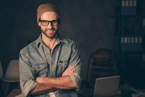 Foto von der Arbeit in der Nacht, Chef, der Kollegen trifft, trägt ein lässiges Outfit, das in der Nähe des Tisches in einem modernen Büro steht