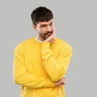 Trauriger-junger-Mann-im-gelben-Sweatshirt-denken