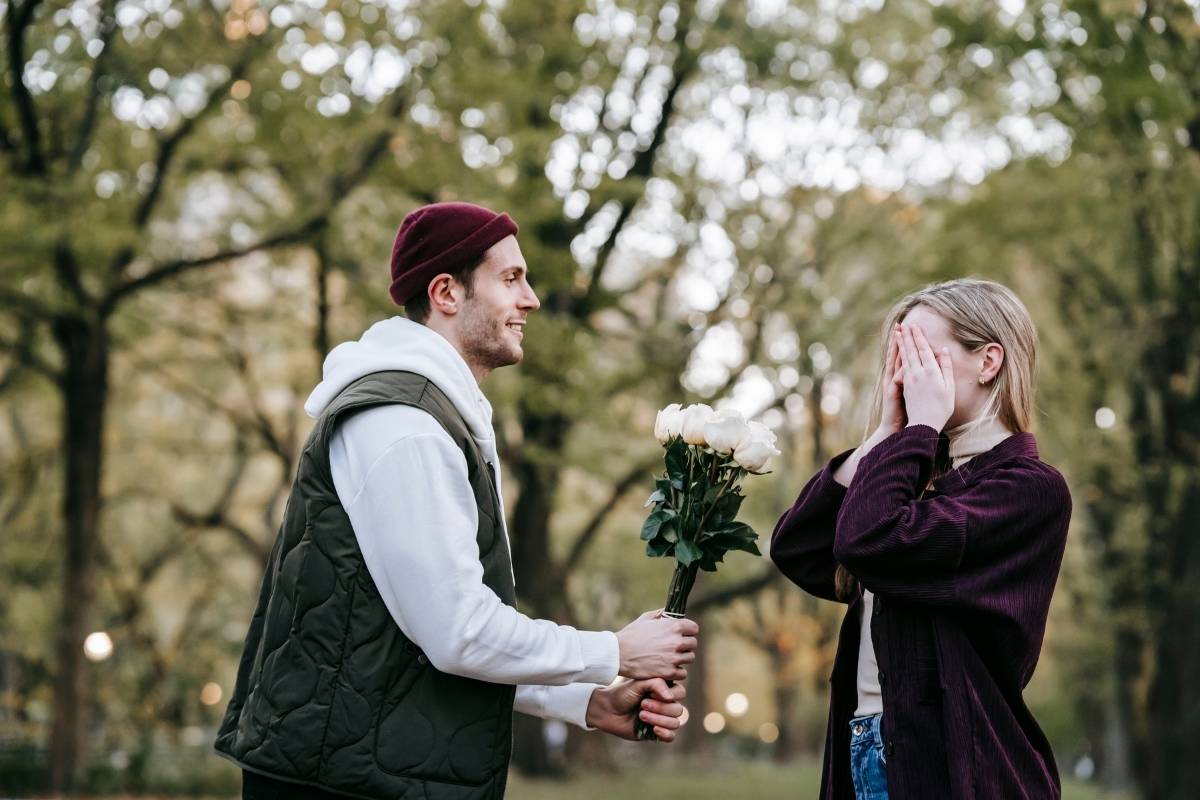 Mann mit Blumen Frau hat die Augen geschlossen