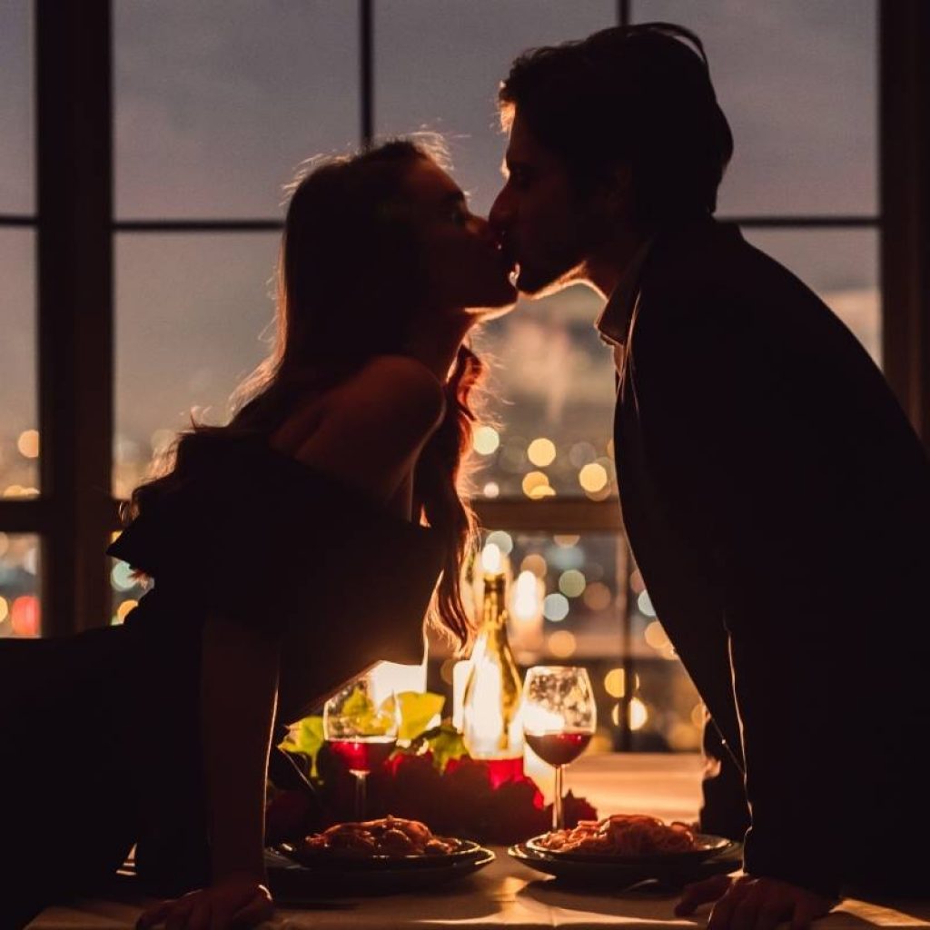romantisches Paar küsst sich über den Tisch